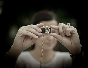 Mergina fotografuojanti mažu fotoaparatu